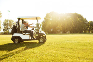 A picture of two golfers riding on the golf cart